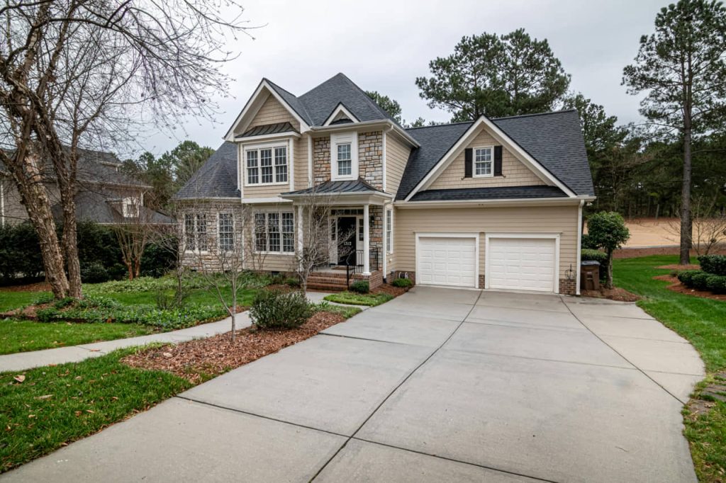 A luxurious home exterior featuring paneling, stonework and siding shingles.